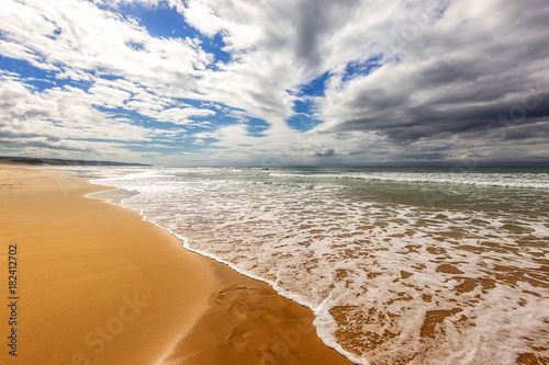Fototapeta Naklejka Na Ścianę i Meble -  stormy sea with sandy beach and dark clouds
