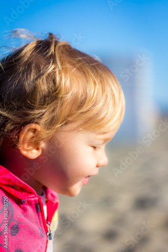 little blonde girl happy at the beach