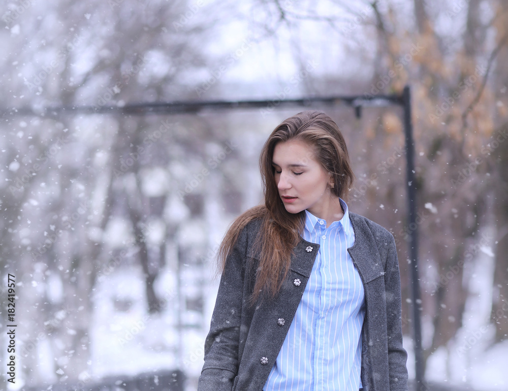 Young girl outdoors in winter. Model girl posing outdoors on a w Young girl outdoors in winter. Model girl posing outdoors on a w