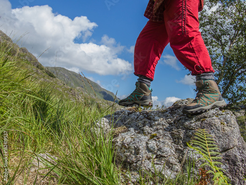 Active woman wearing sports shoes walking across a stone. Travel concept.