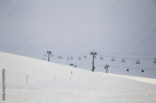 Snowboarder downhill on off piste slope with newly-fallen snow. Caucasus Mountains, Georgia, ski resort Gudauri.