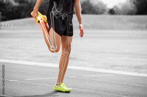 Highlighted bones of athlete man stretching on race track photo
