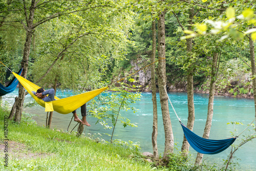  Man relax in a hammock overlooking the mountains and the river