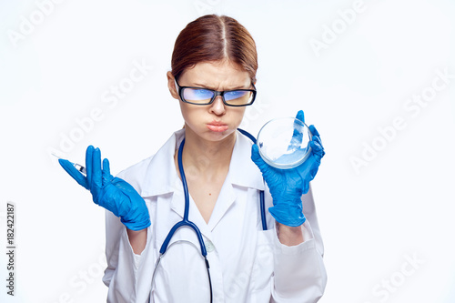 Young beautiful woman with glasses on white isolated background holds a petri dish  doctor  medicine