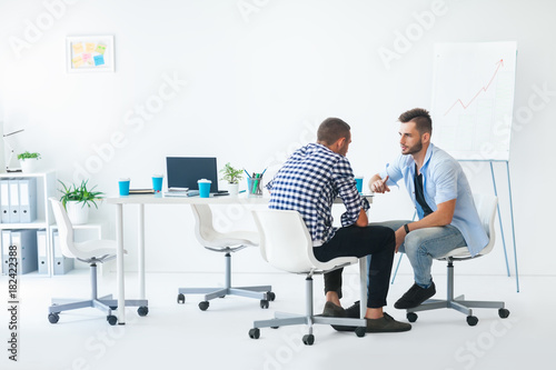 Two businessmen discussing business project at meeting