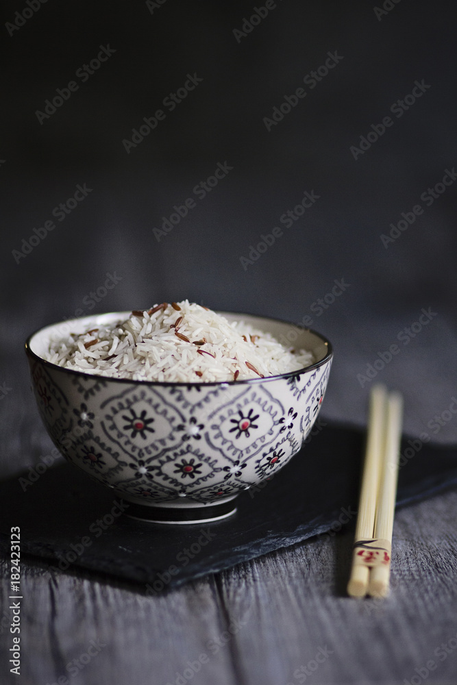 Scodella di riso basmati e riso rosso crudo su tavolo in legno. Cucina orientale Scodella di riso basmati e riso rosso crudo su tavolo in legno. Cucina orientale