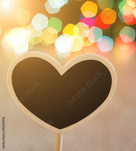 Heart shaped board with Christmas lights in background