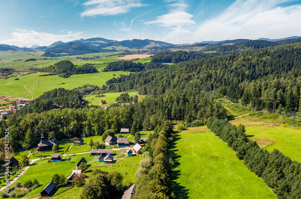 Obraz premium Slovakian town Stara Lubovna on forested hillside. beautiful rural scenery in mountainous area viewed from above on a summer day. 