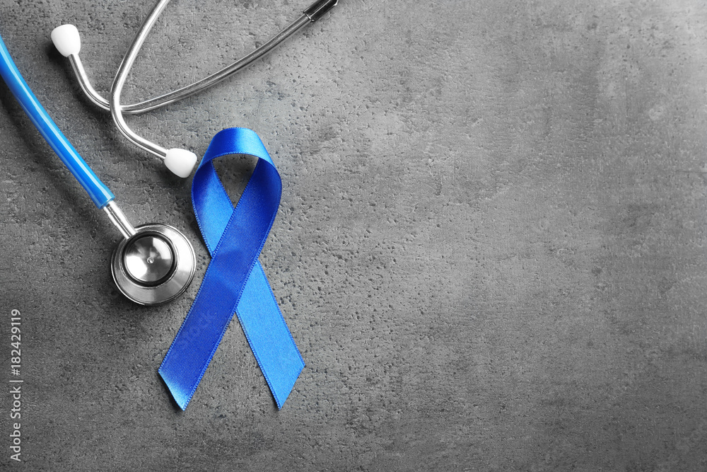 Blue ribbon and stethoscope on grey background. Cancer awareness ...