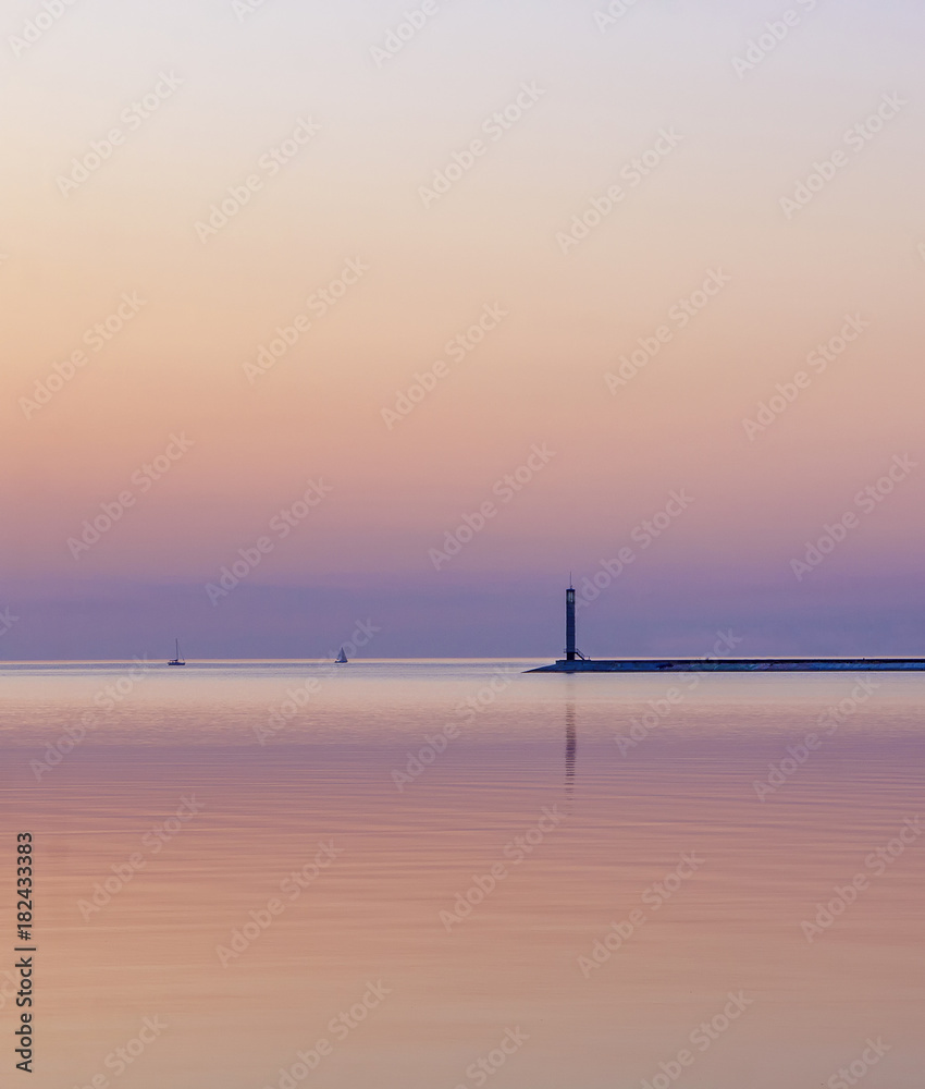 Lighthouse and two yachts at the sunset