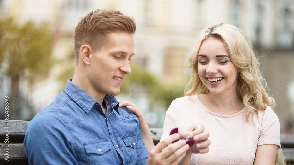 Guy showing engagement ring to girlfriend, happy girl accepting proposal Guy showing engagement ring to girlfriend, happy girl accepting proposal