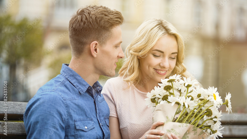 Happy girl smelling nice flowers, gift from beloved boyfriend, romantic date