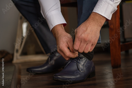 groom business man putting on smart shoes for wedding 