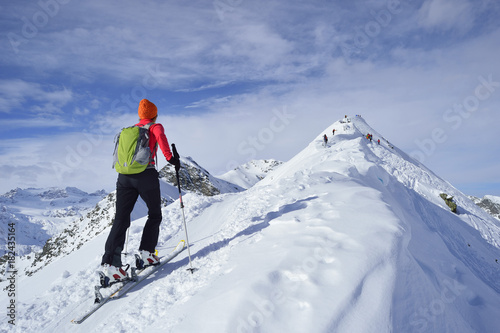 Rear view of woman cross country skiing on mountain top, Tyrol, Italy