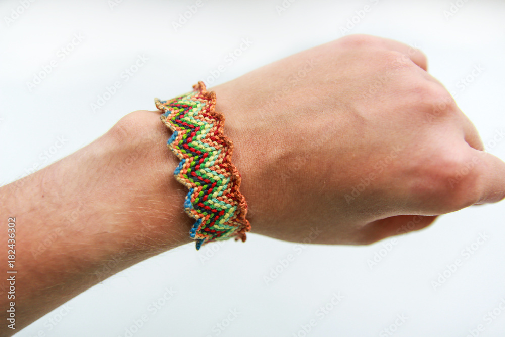Striking bracelet of thread on the girl's hand closeup on white background Striking bracelet of thread on the girl's hand closeup on white background