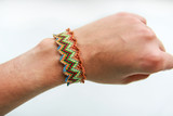 Striking bracelet of thread on the girl's hand closeup on white background