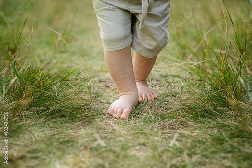 barebood baby feet on a grass healthy walk development 