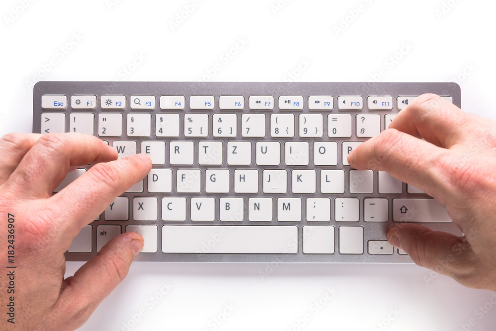 Male hands typing on white computer keyboard Male hands typing on white computer keyboard