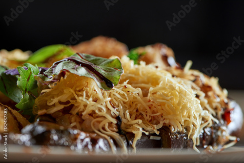 Close up of eggplant served with cheese and greens copyspace layout background eating food nutrition balsamic vinegar delicious dish traditional recipe concept. photo