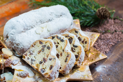Traditional German Christmas raisins and dried fruits cake with sugar powder and Christmas decorations © barmalini