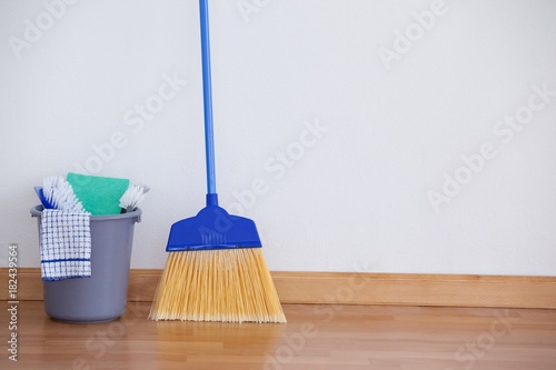 Cleaning equipment on wooden floor against wall