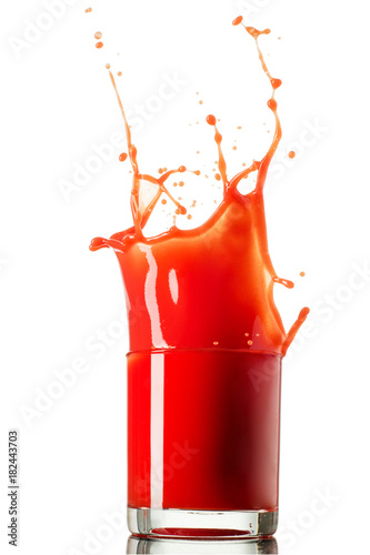 Glass of splashing tomato juice isolated on white. Tomato splash photo