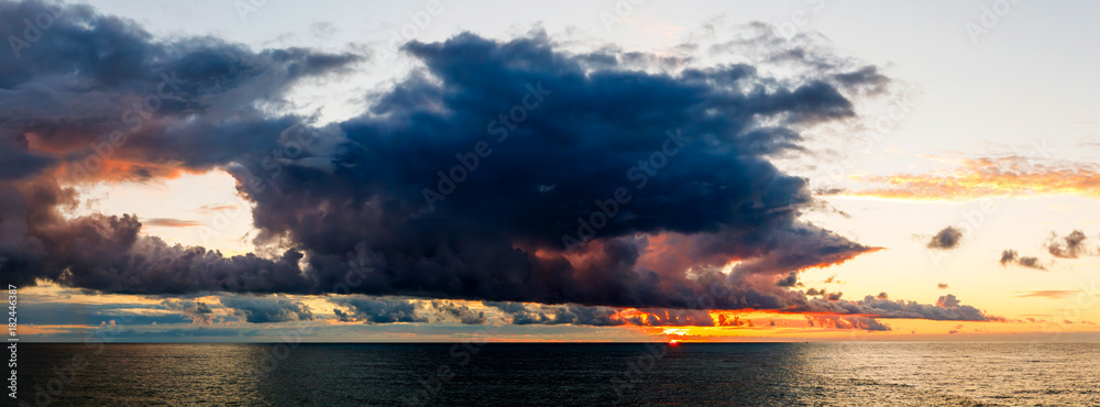 Dramatic sky during a hurricane and sunset over the ocean