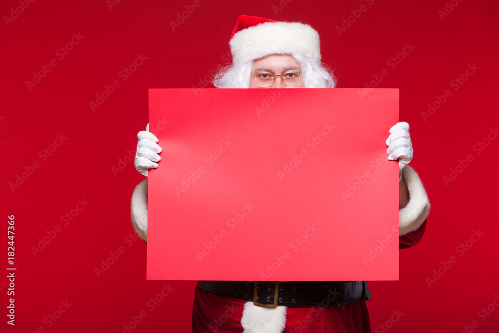 Santa Claus pointing in blank advertisement banner isolated on red background with copy space red leaf Santa Claus pointing in blank advertisement banner isolated on red background with copy space red leaf