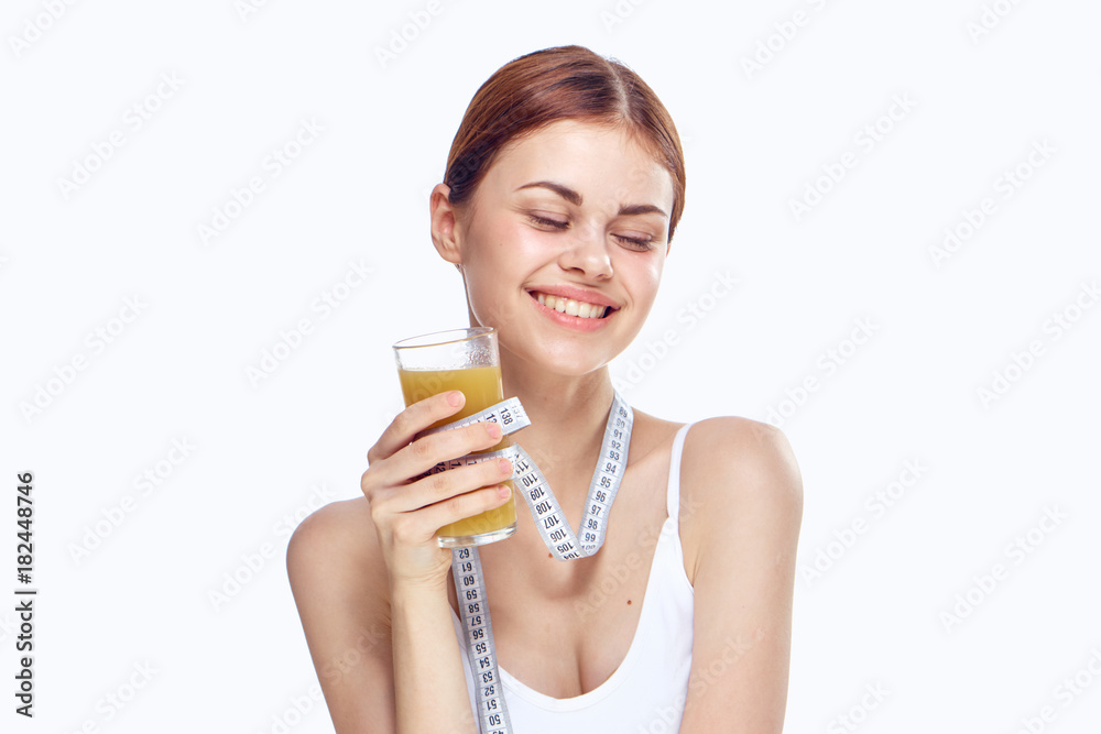Beautiful young woman on a white background holds a glass of juice, diet, fitness, smile Beautiful young woman on a white background holds a glass of juice, diet, fitness, smile