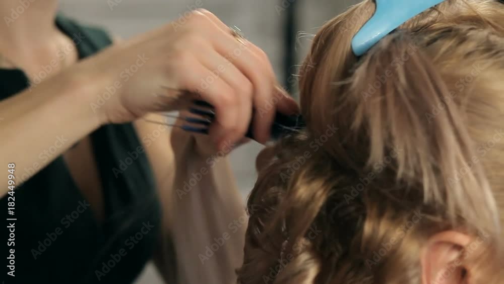 Hairdresser does a hairstyle for a girl Hairdresser does a hairstyle for a girl