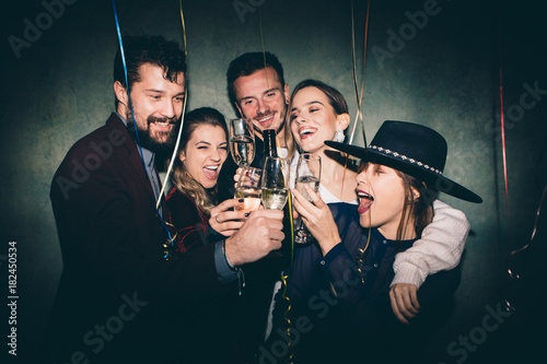 Group of happy friends drinking champagne and celebrating New Year. New year party. Birthday party 