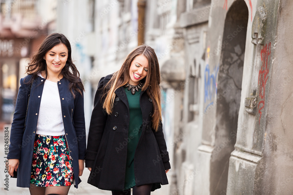 Fototapeta premium Two Best friends women in the city walking and having fun. Friendship and style