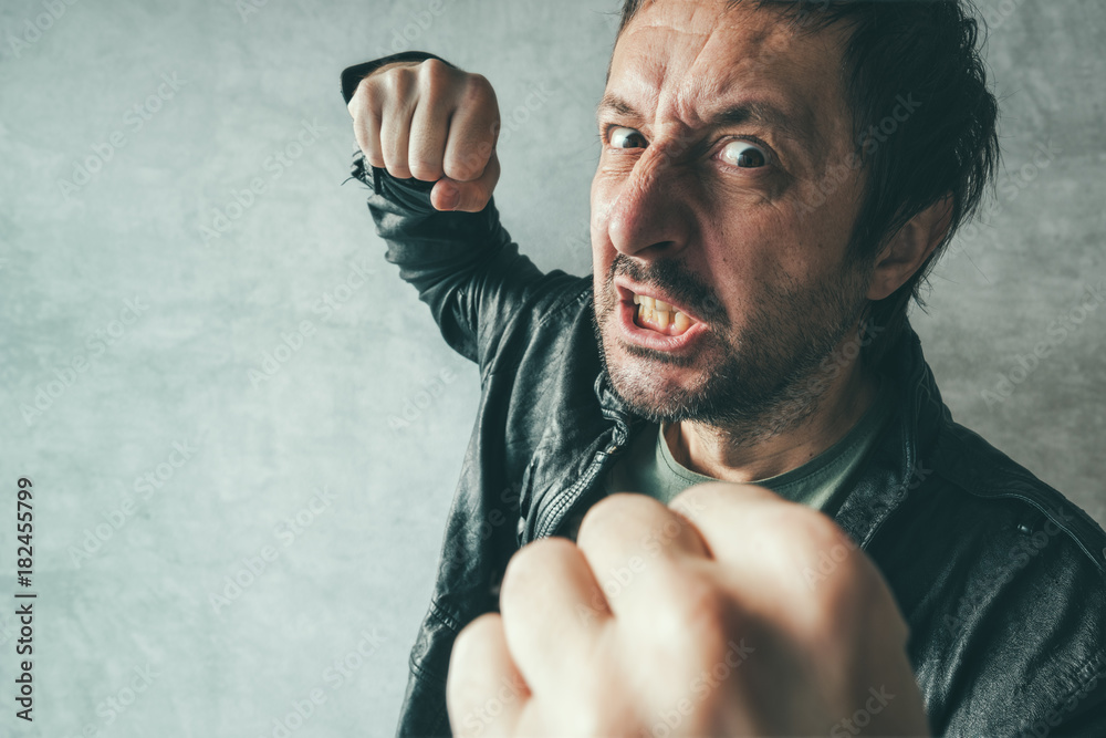 Aggressive man punching with fist, victim's pov - obrazy, fototapety, plakaty 