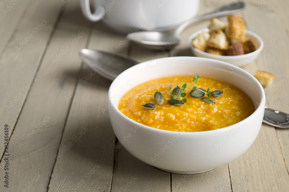 Vegetarian pumpkin soup on a wooden table. Vegetarian pumpkin soup on a wooden table.