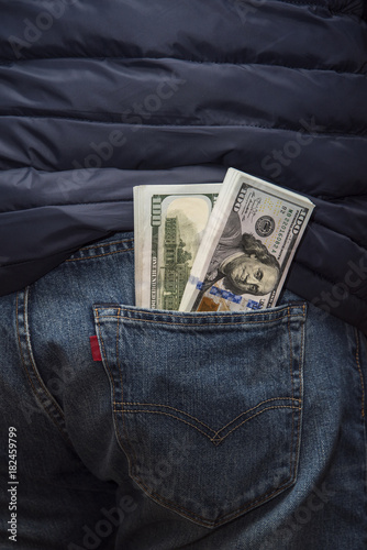 Two bundles of American hundred dollar bills in the back jeans pocket.