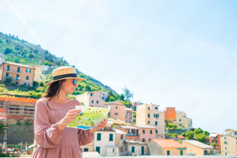 Young woman with map at old village in Liguria, Cinque Terre, Liguria, Italy. European italian vacation.