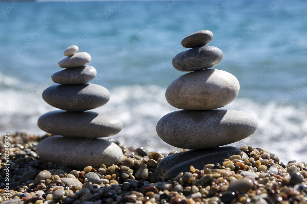 Stones and pebbles stack, harmony and balance, two stone cairns on seacoast Stones and pebbles stack, harmony and balance, two stone cairns on seacoast