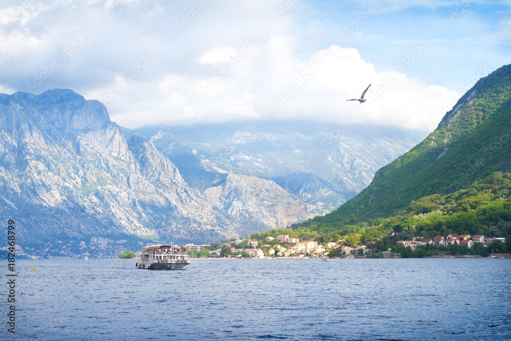 Beautiful scenery with sea and mountains. Tourists travelling by cruise boat, Kotor bay, Montenegro