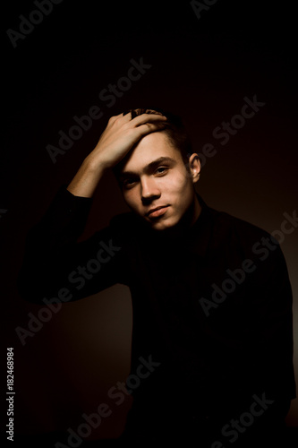 young guy on a dark studio background