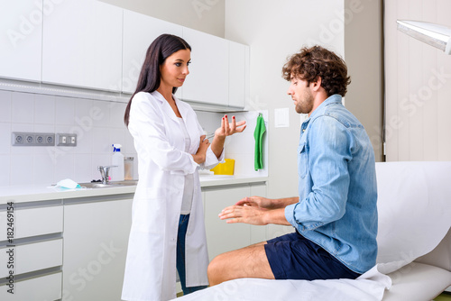 A young male patient in the emergency room discussing with a pro