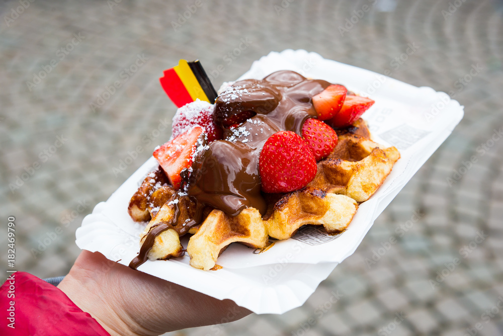 Naklejka premium Traditional Belgian dessert - waffle with strawberry and cream. Brugge, Belgium