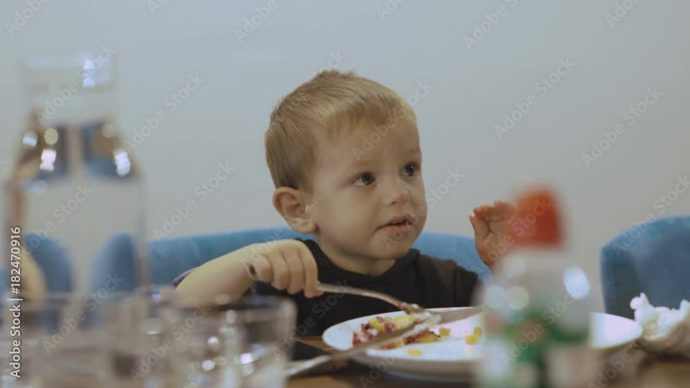 Little funny boy with big eyes eating dish inept. 4K Little funny boy with big eyes eating dish inept. 4K