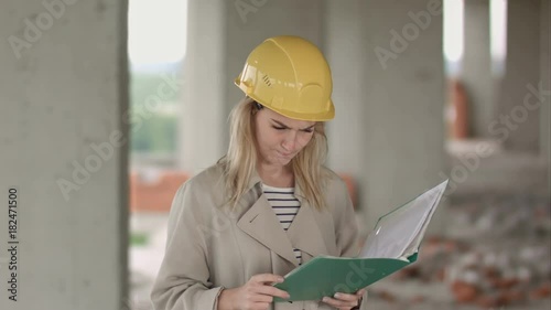 Female engineer is angry and upset reading construction plan photo