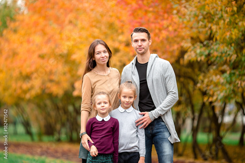 Portrait of happy family of four in autumn day