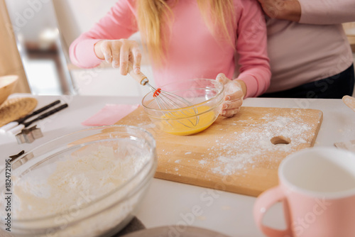 According to the recipe. Close up of a bowl with whipped eggs in it being used for cooking