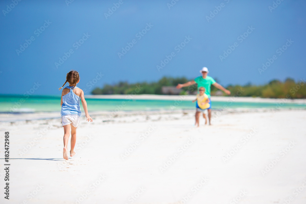 Young family enjoying beach summer vacation. Kids and dad together on the beach