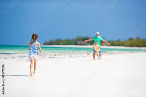 Young family enjoying beach summer vacation. Kids and dad together on the beach