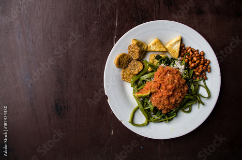 Indonesian dish kankung plecing (spicy water spinach dish) typical for Lombok island with space on left side.