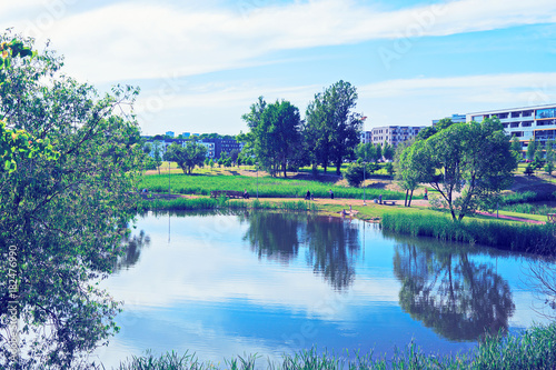 Landscape with park and pond and modern apartment buildings