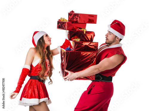 Handsome young man and pretty young woman in Santa Claus hat standing holding colorful festive Christmas gifts to celebrate the season, on white background